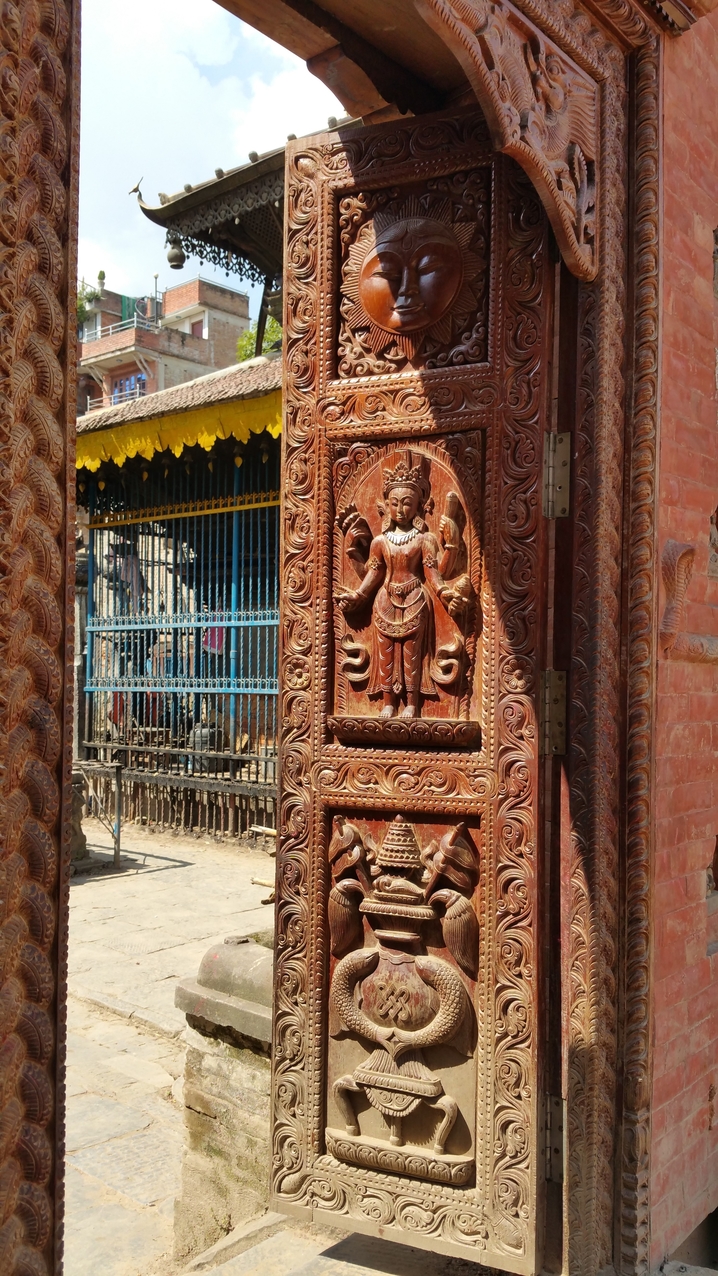 Eine Seitentür der Shree Samaj Sudhar Secondary School ist mit detailreichen Holzschitzereien versehen.

