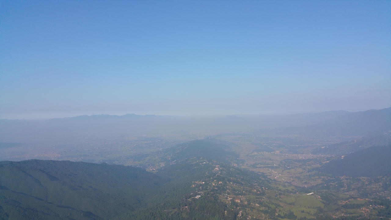 Anflug über die letzten Berge der östlichen Begrenzung des Kathmandu Tals. Die Dunstglocke über Kathmandu läßt sich schon erahnen.
