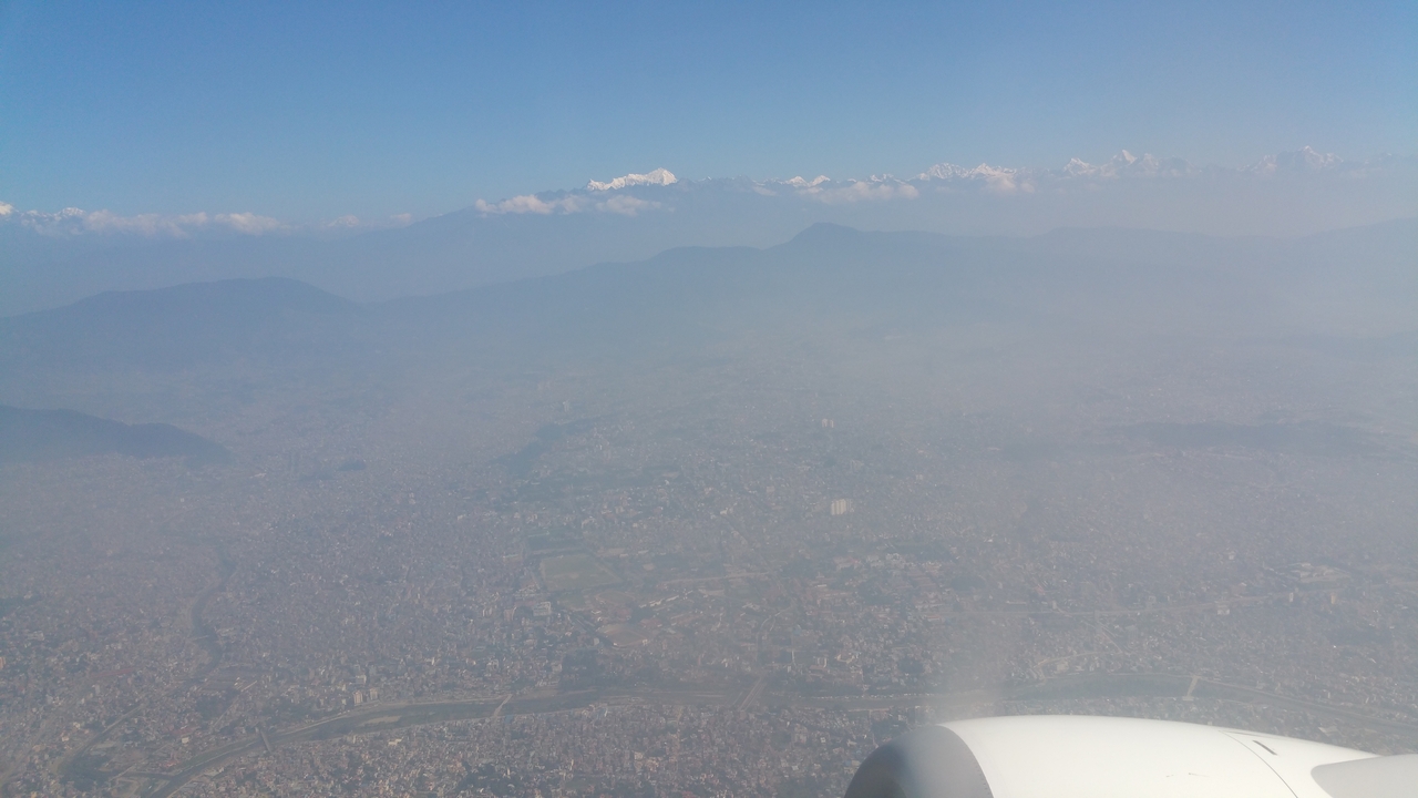 Am Horizont im Norden tauchen die ersten Gipfel des Himalaya aus dem Dunst, während die Stadt langsam in dem braunen Smog versinkt.
