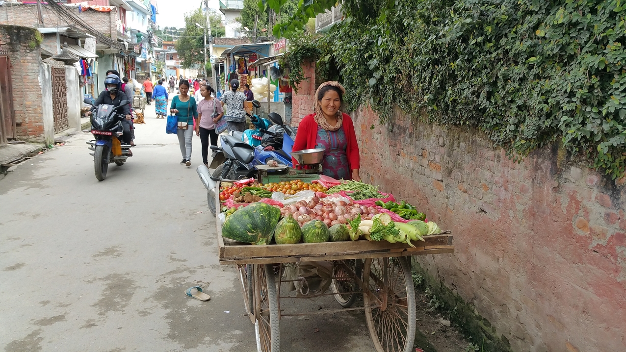 Eine Marktfrau freut sich über den aufgerundeten Preis für drei Zwiebeln.
